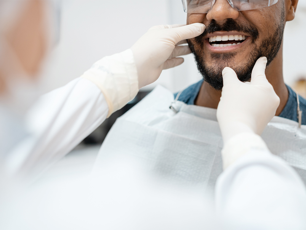 Image of a dentist examining a smiling patient, representing dental care or consultation.