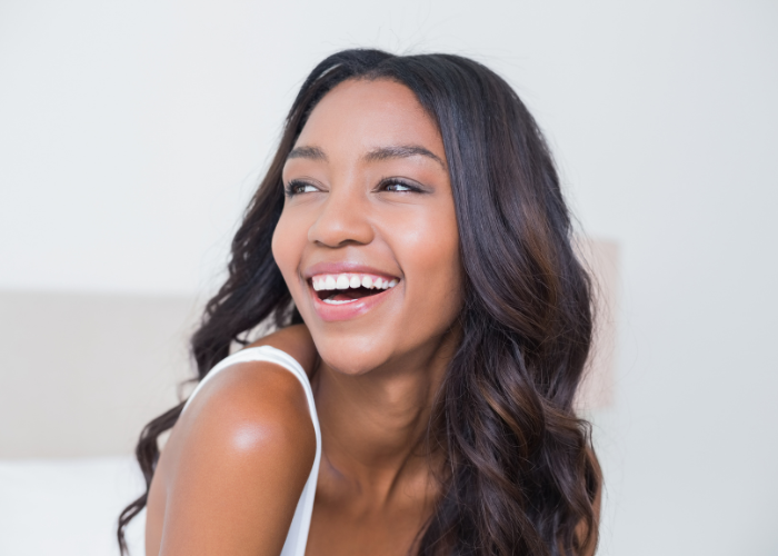 Image of a smiling woman with long dark hair, representing a happy dental patient.